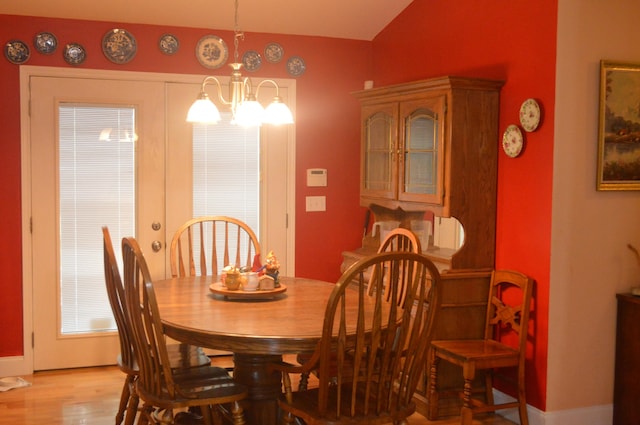 dining room featuring an inviting chandelier, light hardwood / wood-style flooring, and french doors