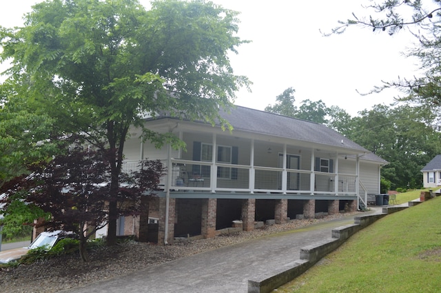 exterior space featuring cooling unit, a balcony, and a front lawn