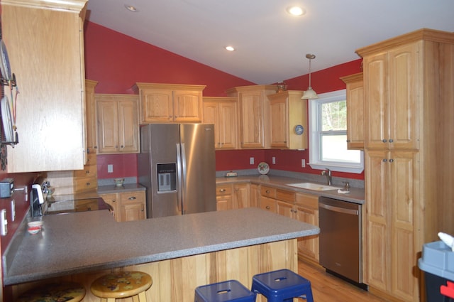 kitchen with light hardwood / wood-style floors, a breakfast bar area, stainless steel appliances, lofted ceiling, and sink