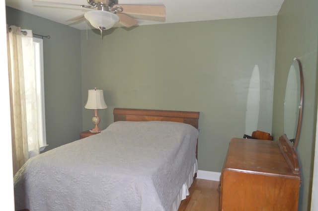 bedroom with light wood-type flooring, ceiling fan, and multiple windows