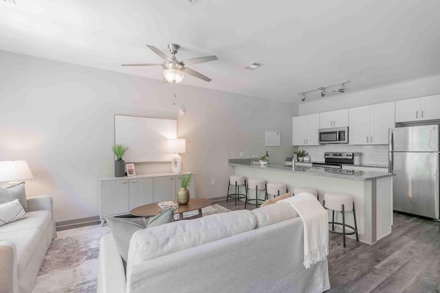 living room featuring light wood-type flooring, sink, and ceiling fan