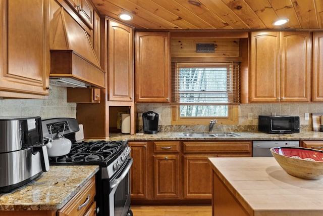 kitchen featuring light stone counters, custom exhaust hood, sink, light hardwood / wood-style flooring, and stainless steel appliances