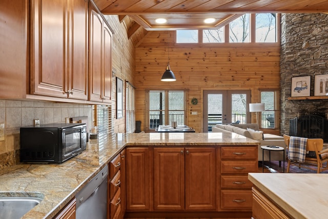 kitchen featuring wood ceiling, dishwasher, wooden walls, a stone fireplace, and french doors