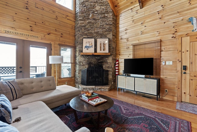 835 Rushing Water Trl, Rising Fawn, GA 30738 - living room featuring plenty of natural light, wood finished floors, wooden walls, french doors, and a stone fireplace