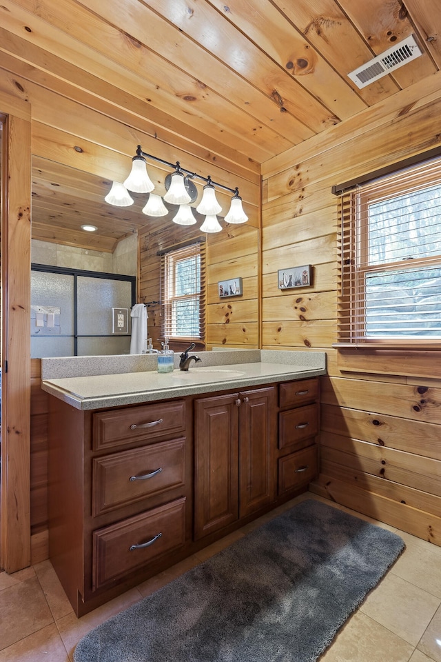 bathroom featuring vanity, wood walls, tile patterned flooring, and a shower with door