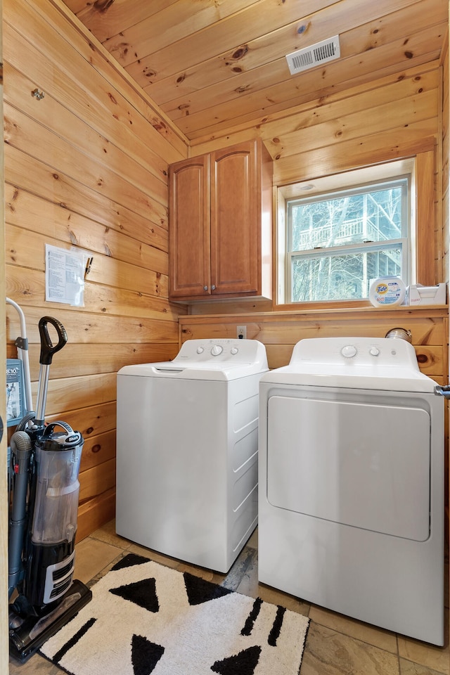 washroom with wooden ceiling, separate washer and dryer, wood walls, and cabinets