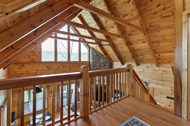 interior space with wood ceiling, wooden walls, lofted ceiling with beams, and hardwood / wood-style flooring