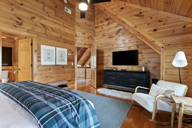 bedroom featuring wood ceiling, light wood-type flooring, beamed ceiling, wood walls, and ceiling fan