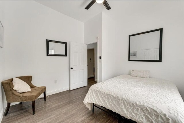 bedroom with ceiling fan, dark hardwood / wood-style floors, and high vaulted ceiling