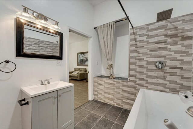 bathroom with tile walls, tile patterned floors, independent shower and bath, and vanity