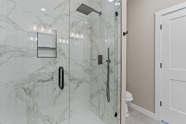 bathroom featuring tile patterned floors, a shower with door, and toilet