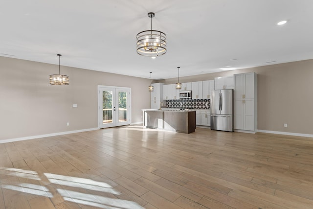 unfurnished living room with french doors, light wood-type flooring, and sink