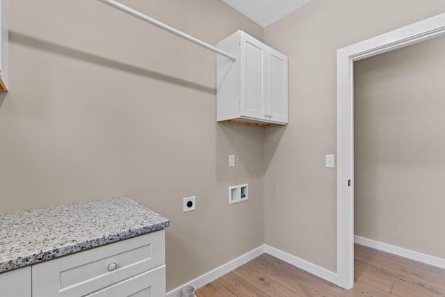 laundry room featuring hookup for an electric dryer, washer hookup, light hardwood / wood-style floors, and cabinets