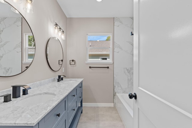 bathroom with tile patterned flooring, vanity, and a healthy amount of sunlight