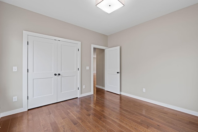 unfurnished bedroom featuring hardwood / wood-style floors and a closet