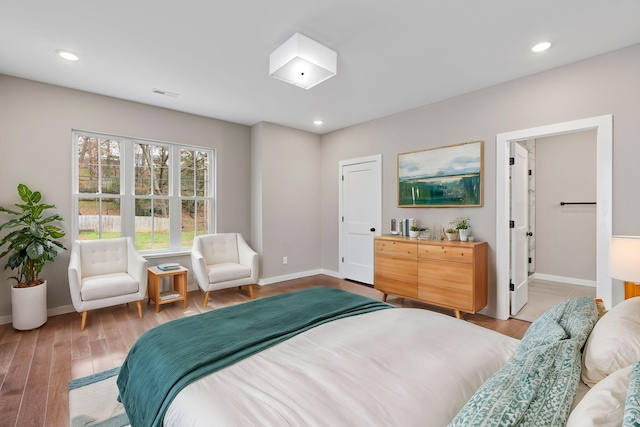 bedroom with light hardwood / wood-style flooring and ensuite bath