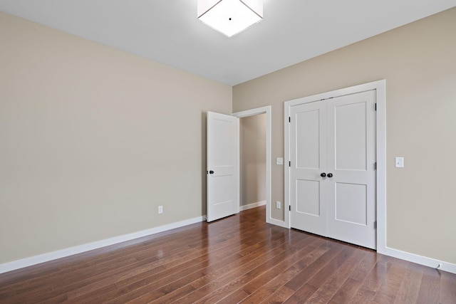 unfurnished bedroom with dark hardwood / wood-style floors and a closet