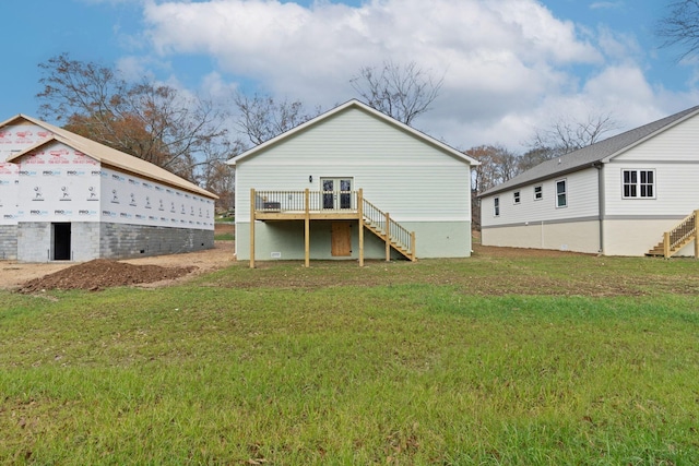 rear view of property featuring a yard and a wooden deck