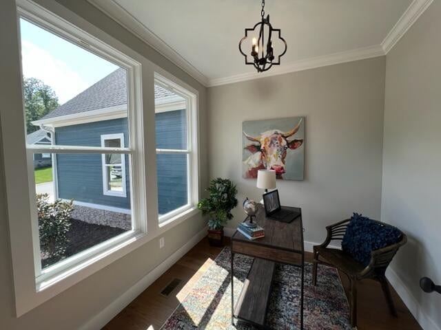 home office with a healthy amount of sunlight, dark wood-type flooring, and a notable chandelier