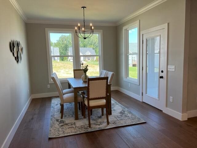 dining area featuring a notable chandelier, dark hardwood / wood-style floors, and ornamental molding