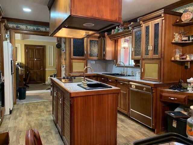 kitchen featuring light hardwood / wood-style flooring, a center island with sink, tasteful backsplash, and sink