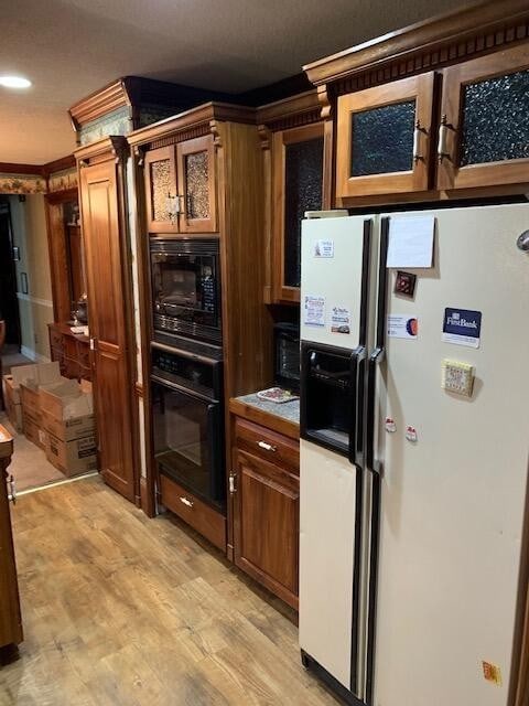 kitchen with light hardwood / wood-style flooring and black appliances