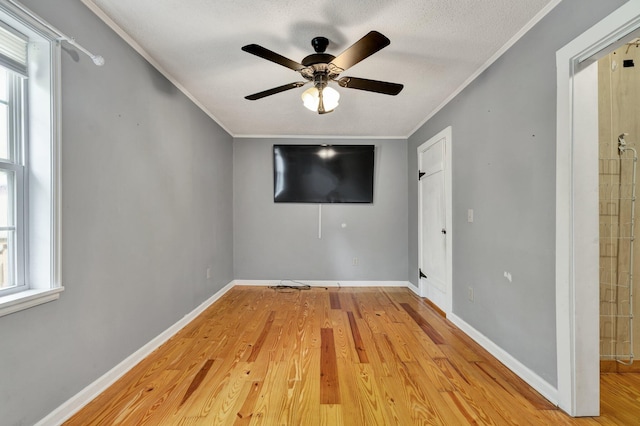 spare room featuring ceiling fan, a textured ceiling, crown molding, and light hardwood / wood-style floors