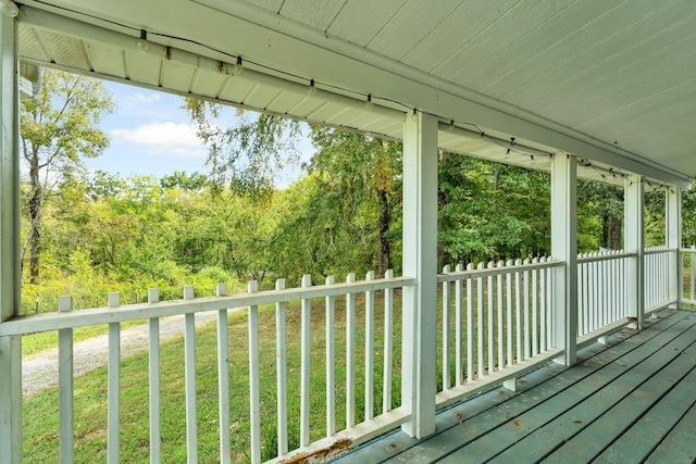 wooden terrace featuring a lawn