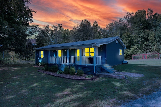 single story home featuring covered porch and a yard