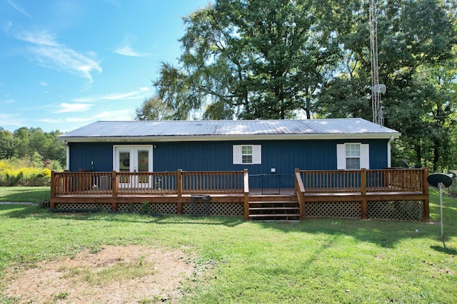 rear view of property featuring a wooden deck and a lawn