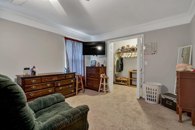 living area with a textured ceiling, ceiling fan, light colored carpet, and crown molding