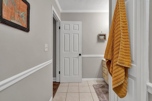 hall featuring ornamental molding, a textured ceiling, and light tile patterned floors