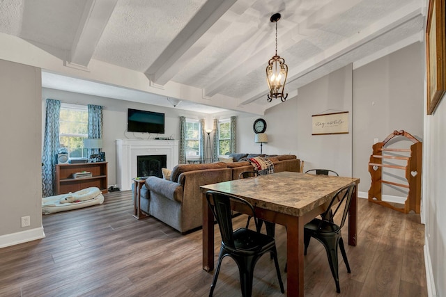 dining area with an inviting chandelier, a textured ceiling, lofted ceiling with beams, and dark hardwood / wood-style flooring