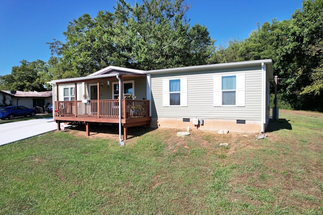 manufactured / mobile home featuring a wooden deck and a front lawn