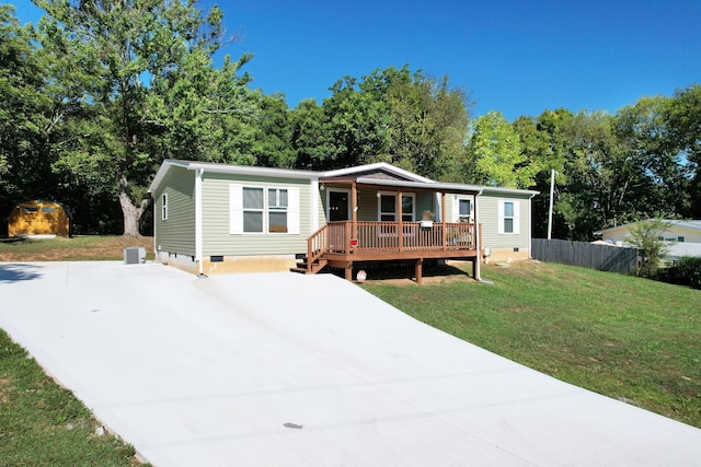 manufactured / mobile home featuring a storage shed and a front lawn