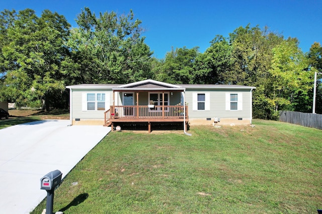 manufactured / mobile home featuring a front yard and a wooden deck