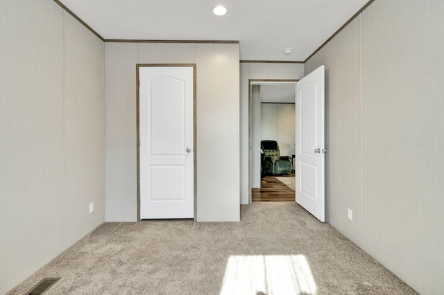 unfurnished bedroom featuring light carpet and ornamental molding