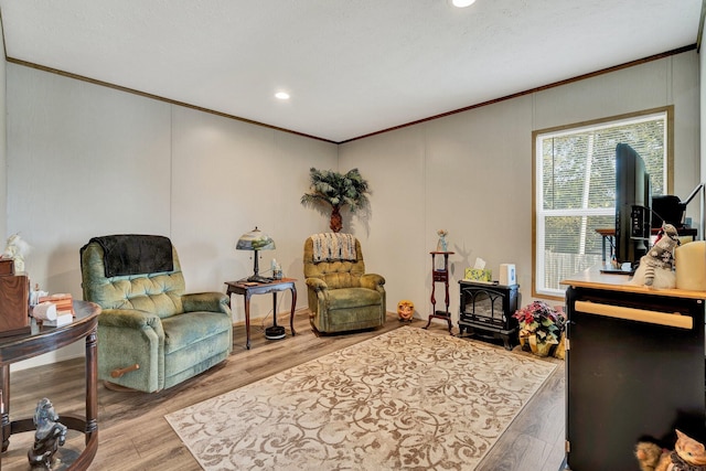 sitting room featuring a textured ceiling, ornamental molding, and light hardwood / wood-style flooring