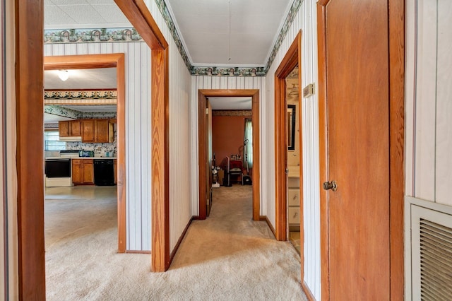 corridor featuring ornamental molding and light colored carpet