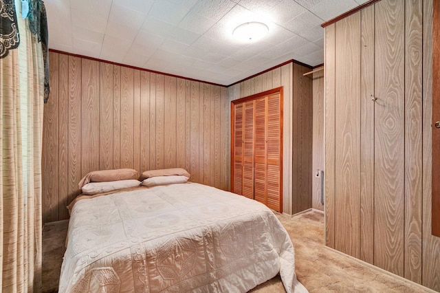 bedroom featuring wood walls, light colored carpet, and a closet