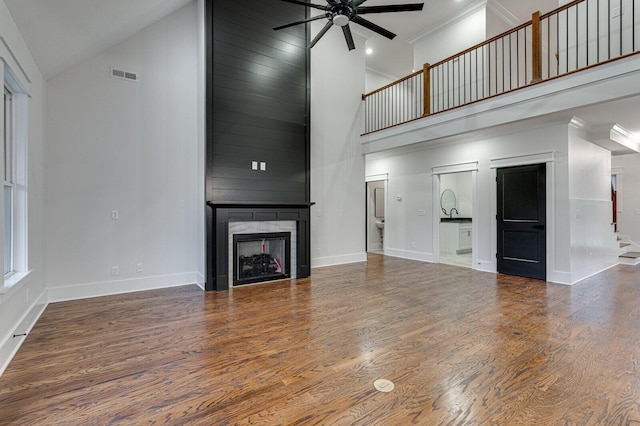 unfurnished living room featuring ceiling fan, a fireplace, high vaulted ceiling, and wood-type flooring