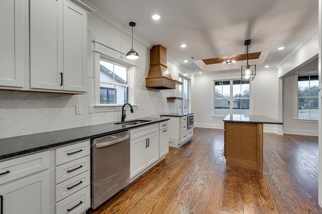 kitchen with pendant lighting, white cabinetry, stainless steel dishwasher, and sink