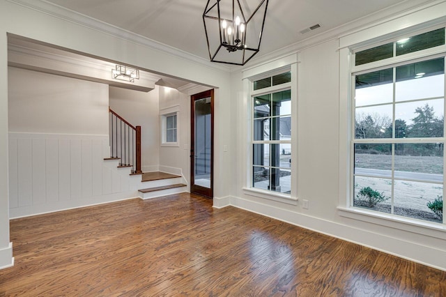 interior space with a notable chandelier, dark hardwood / wood-style floors, and ornamental molding