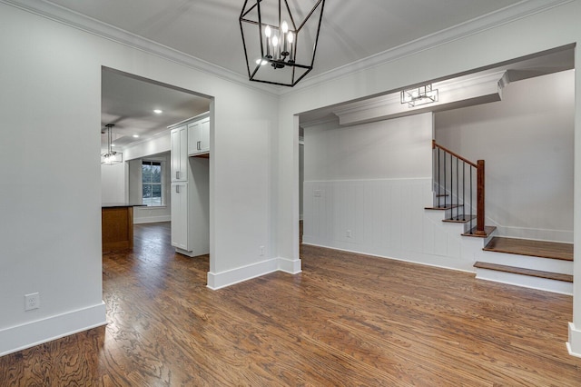 interior space featuring dark hardwood / wood-style floors, ornamental molding, and a notable chandelier