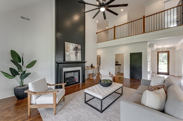 111 Arthur Ln NW, Cleveland, TN 37312 - living area featuring a towering ceiling, a ceiling fan, wood finished floors, ornamental molding, and a fireplace