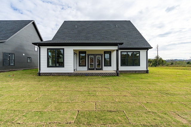 rear view of property featuring a lawn