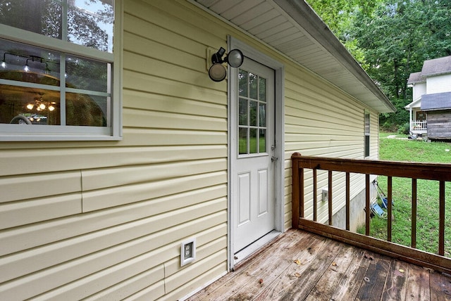 doorway to property featuring a lawn and a deck