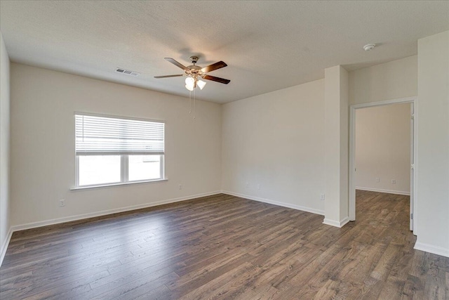 empty room with ceiling fan, dark hardwood / wood-style floors, and a textured ceiling