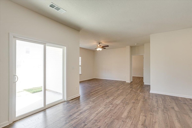 unfurnished room featuring a textured ceiling, ceiling fan, and light hardwood / wood-style flooring