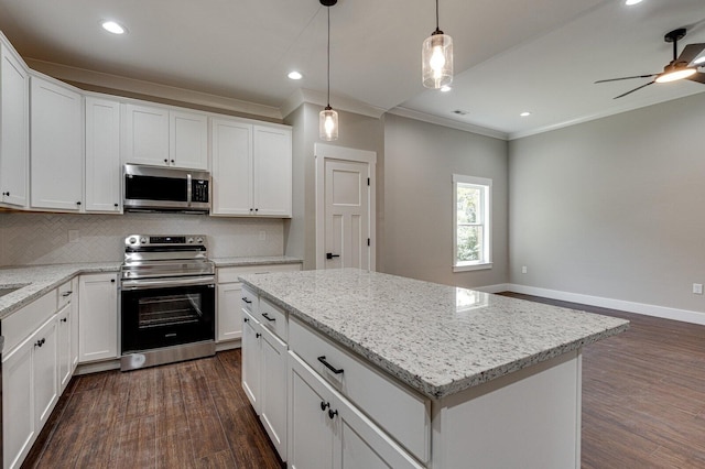 kitchen featuring appliances with stainless steel finishes, white cabinets, a kitchen island, dark hardwood / wood-style flooring, and ceiling fan